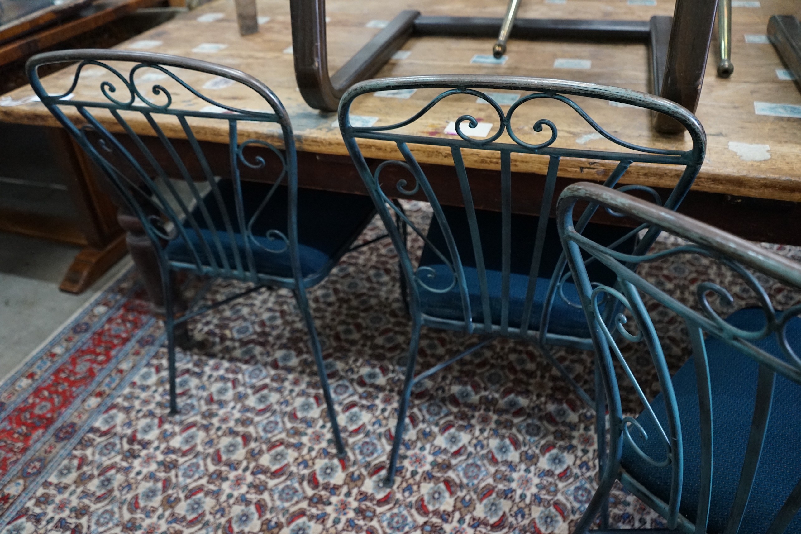 A set of four painted wrought iron dining chairs